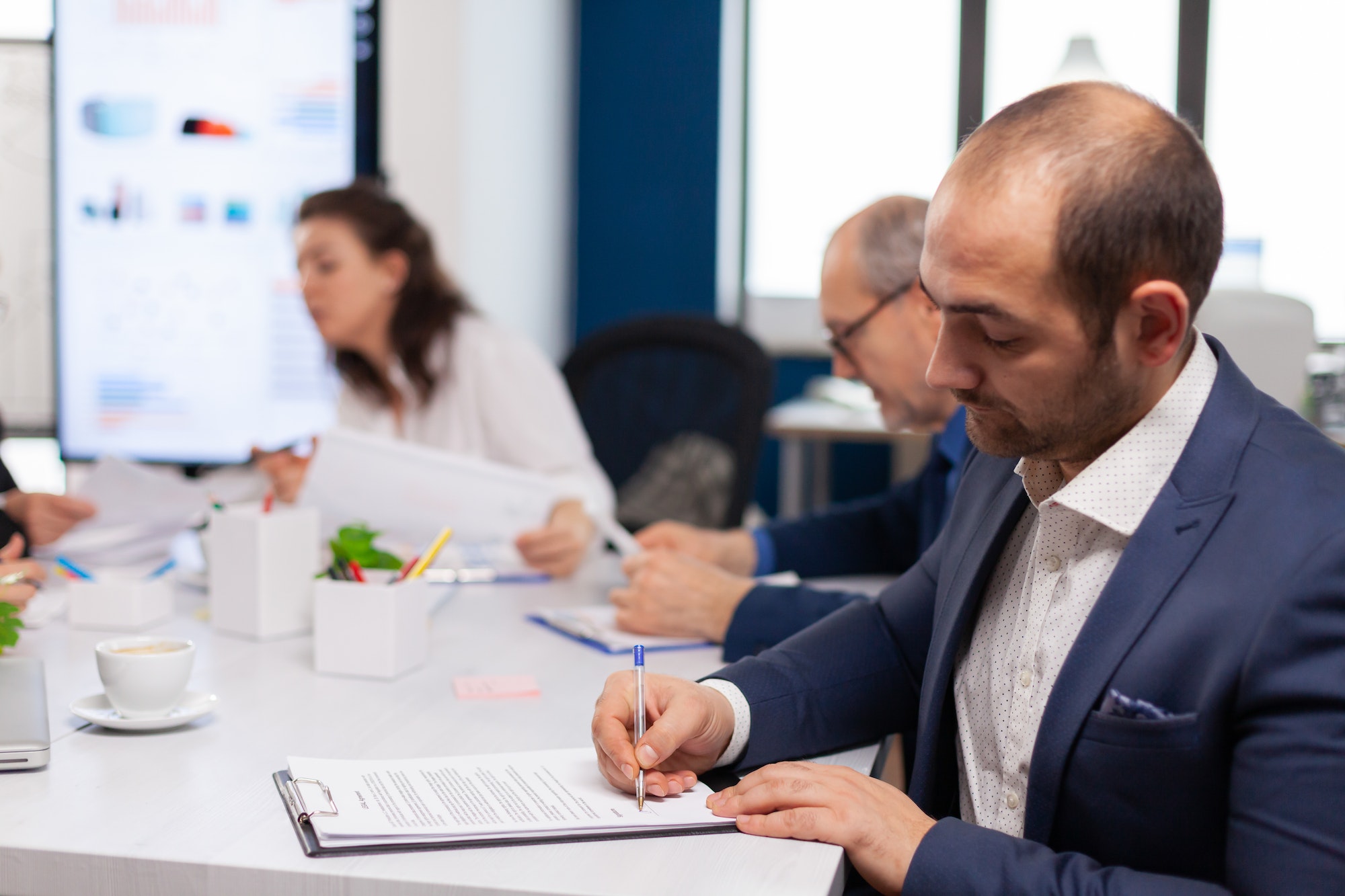 Businessman reading paper document, discussing contract