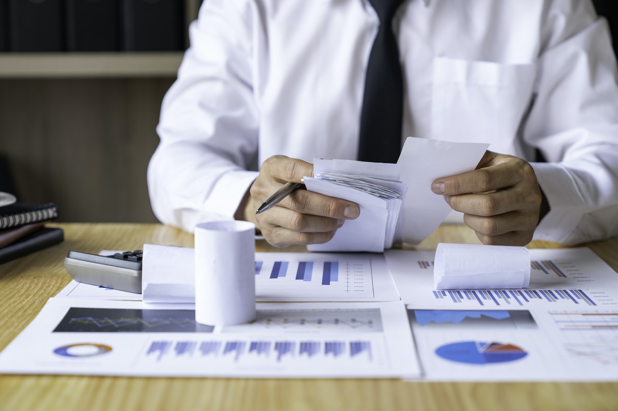 Close-up of businessman's hands collecting bills for tax refund and tax savings, finance banking and