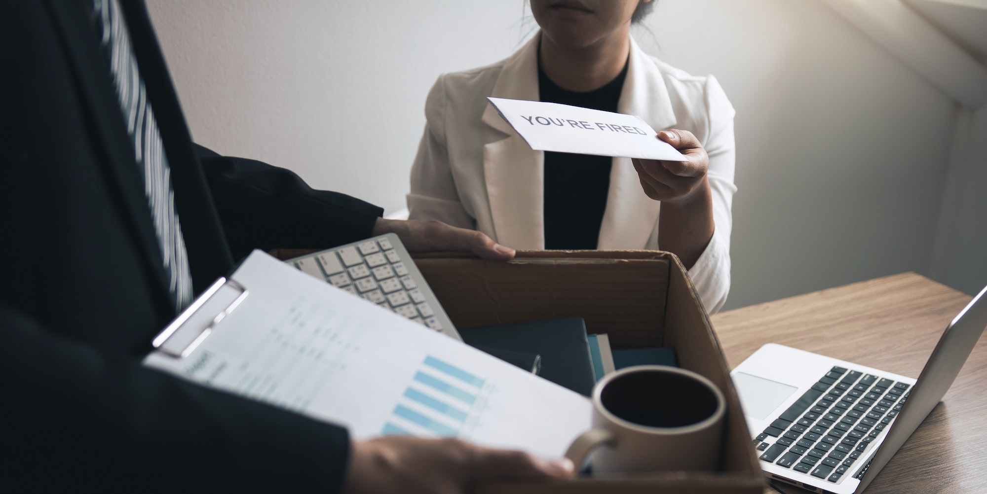 Female manager submits a resignation letter or envelope to the male employee at the office.