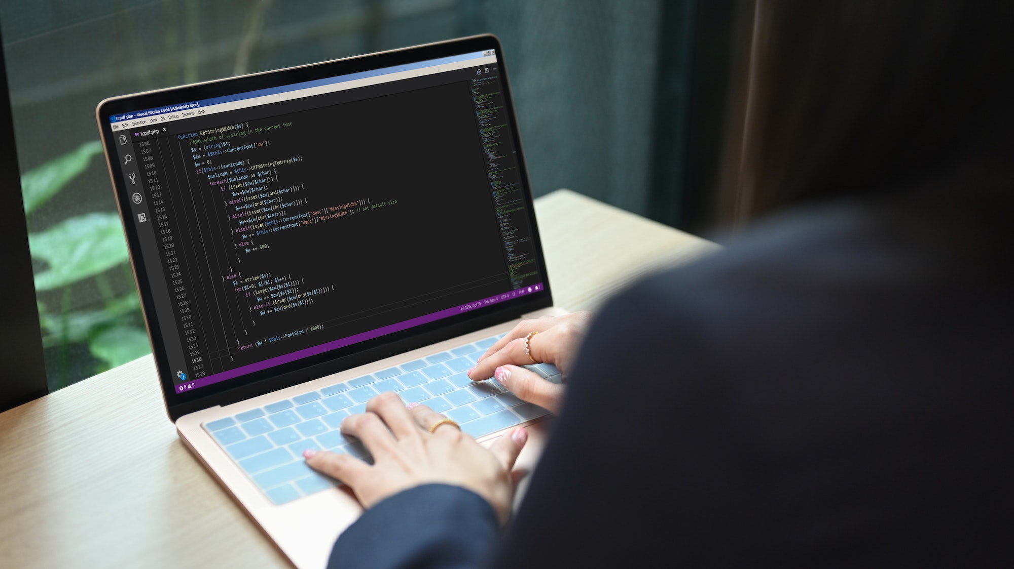 Female software developer on web site project, programming on desktop computer.