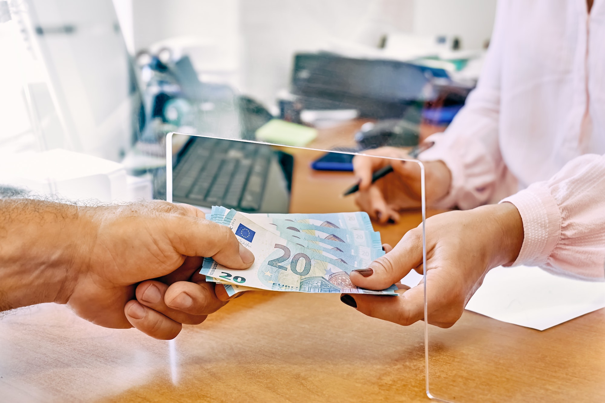 Hand of female social worker taking or giving euro money from client