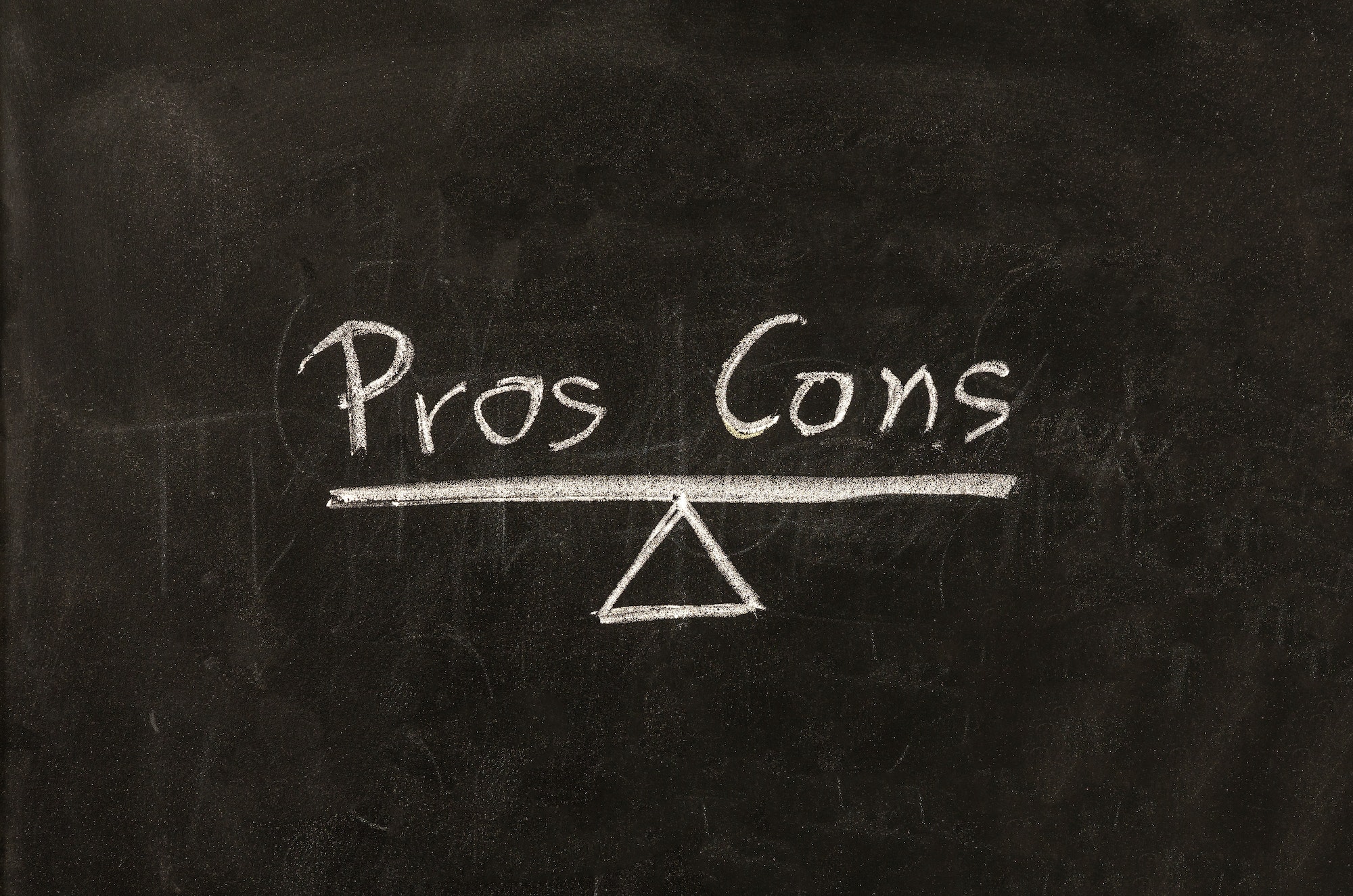 Pros contra cons concept. Empty list on blackboard background, for decision making..