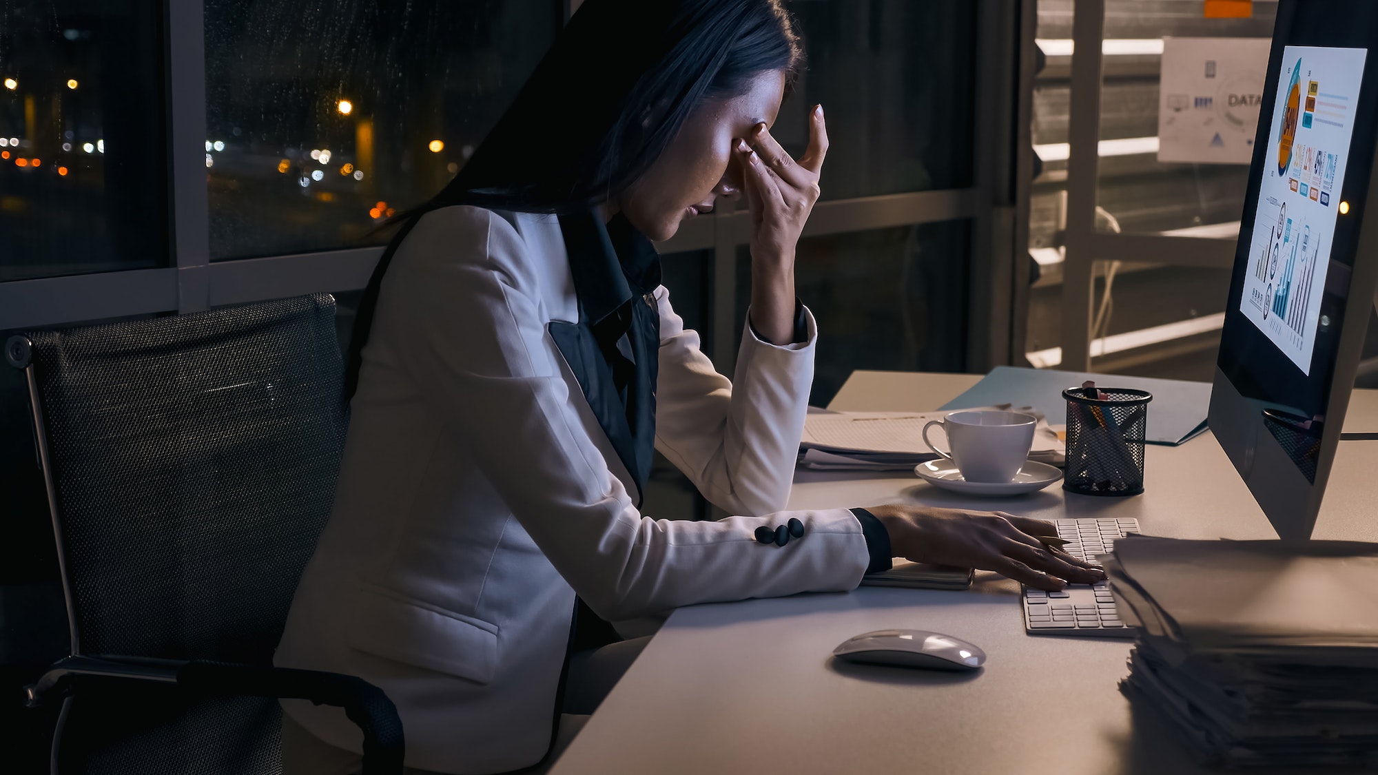 Stressed young Asian businesswoman working overtime at the office.