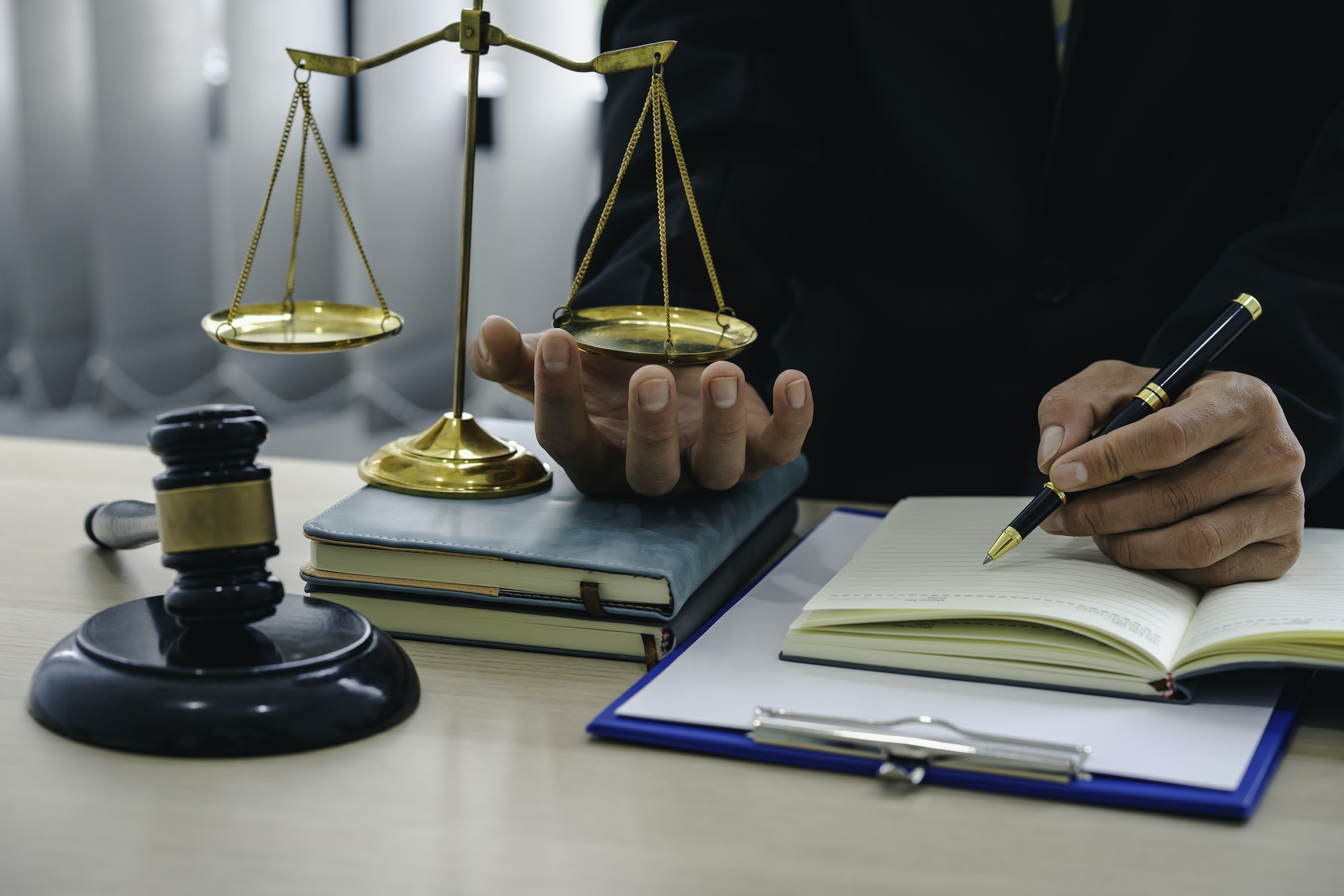 A lawyer or judge is writing a memorandum of legal testimony to a client in the lawyer's office. leg