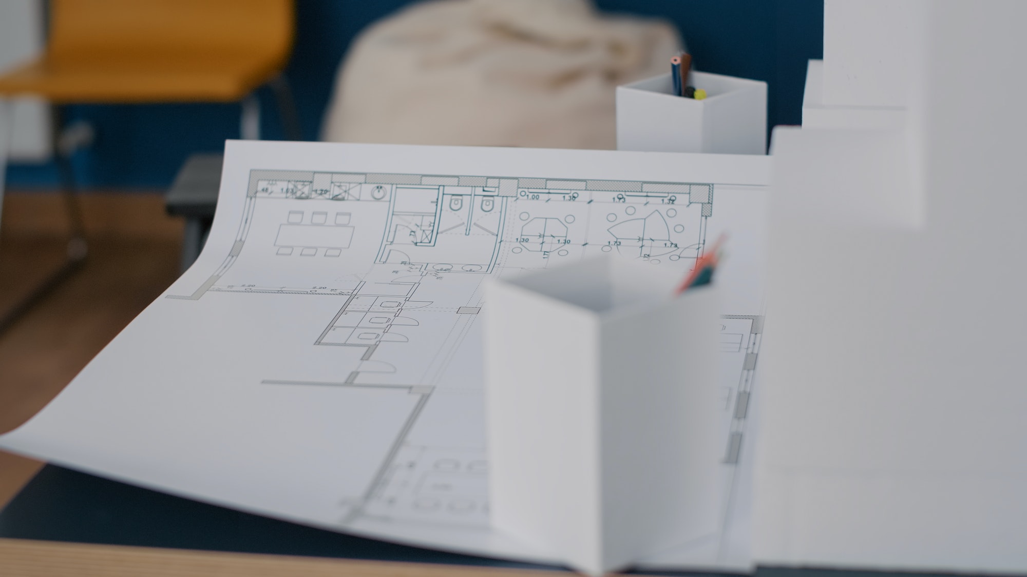 Close up of paper with blueprints plans on table in architectural office