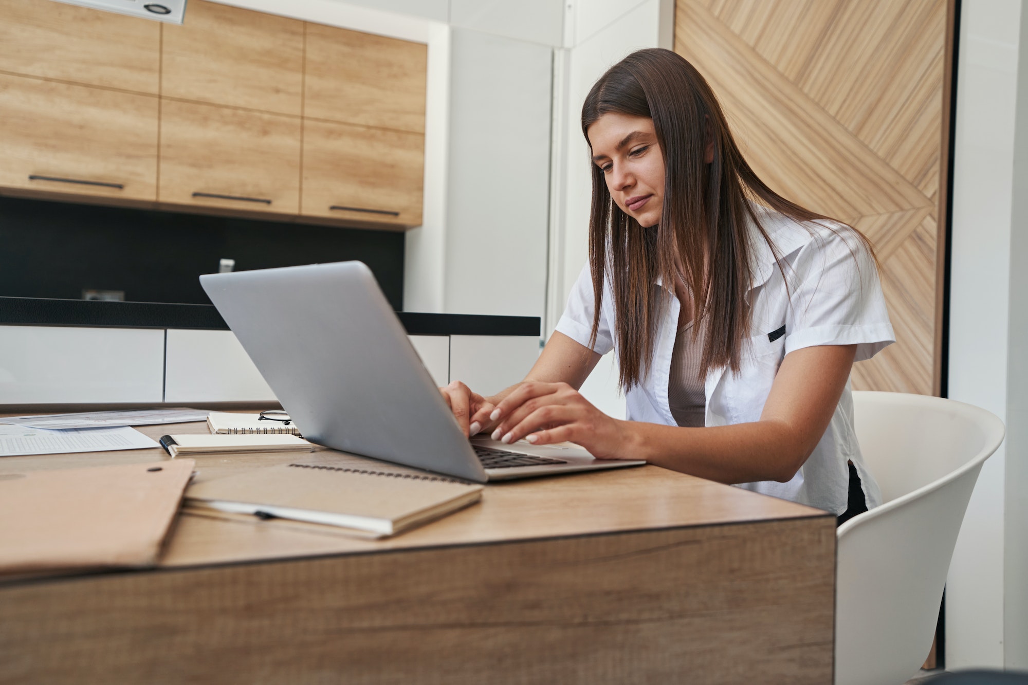 Female telecommuter typing on her notebook computer