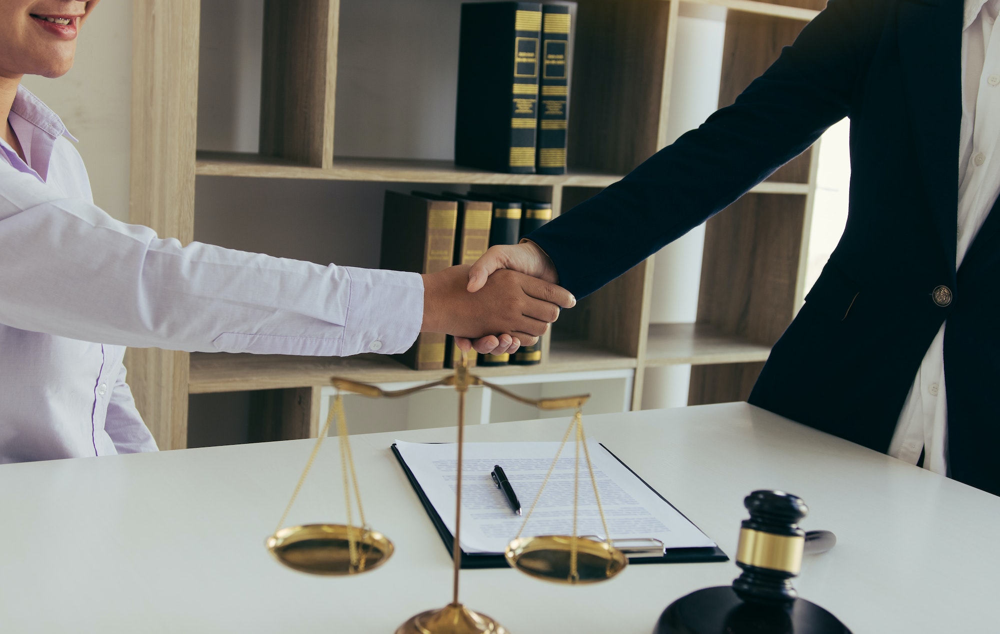 Lawyer is currently shaking hands with the client about the success in resolving the case.